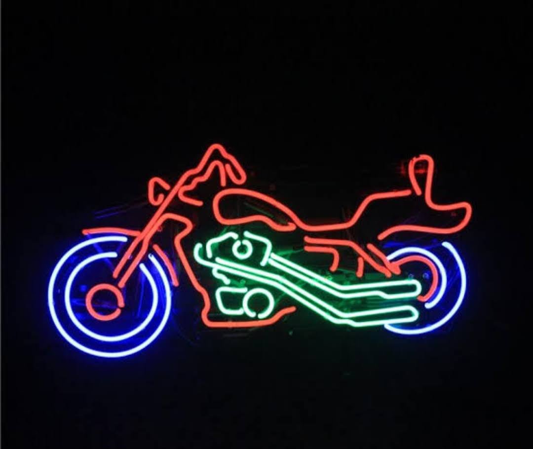 Kırmızı, mavi ve yeşil cam neonla tasarlanan motosiklet figürü